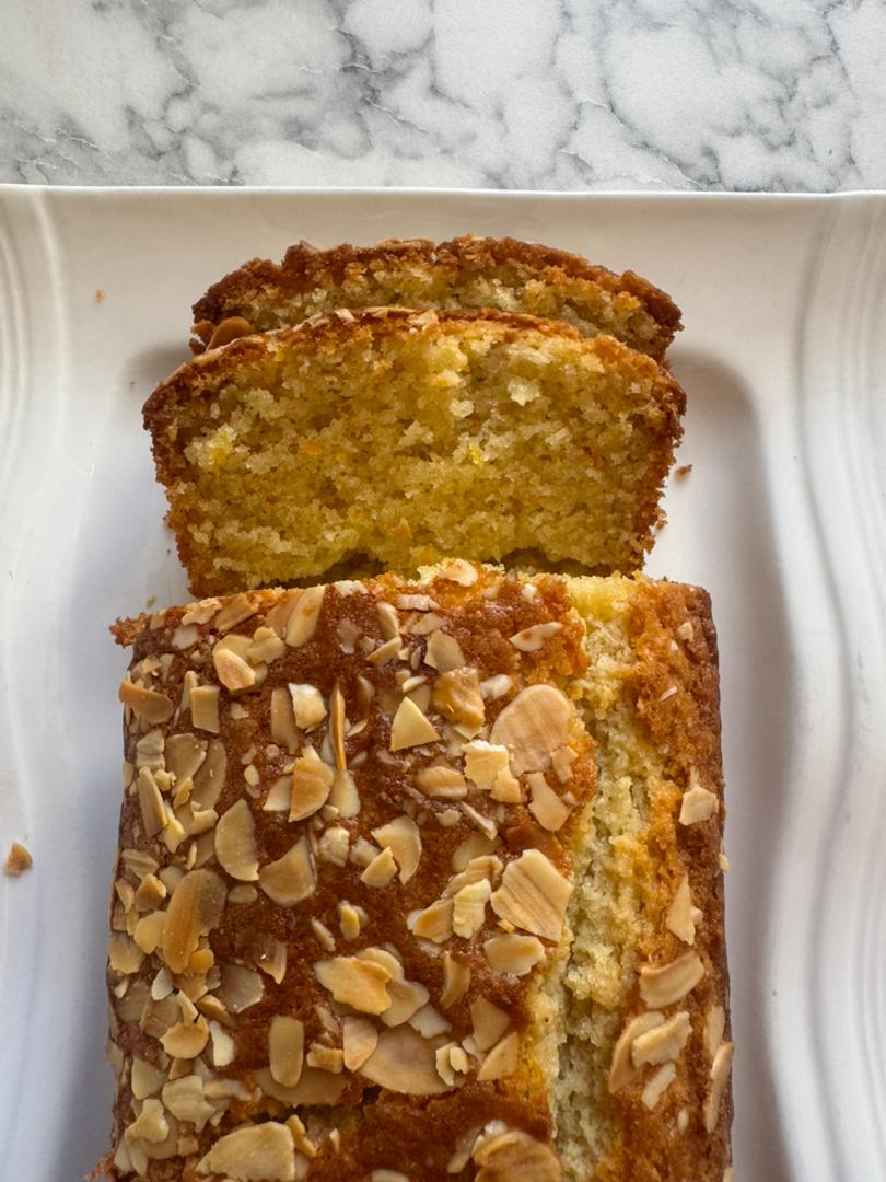 Orange almond loaf sliced on a white plate